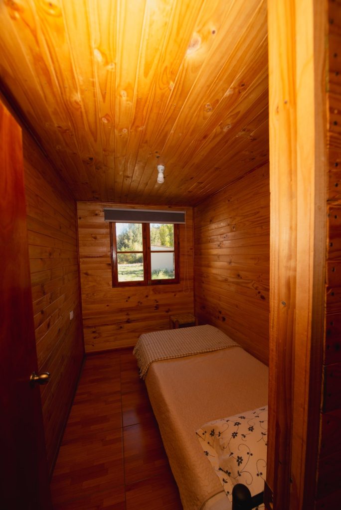 Dormitorio con camas individuales y paredes de madera