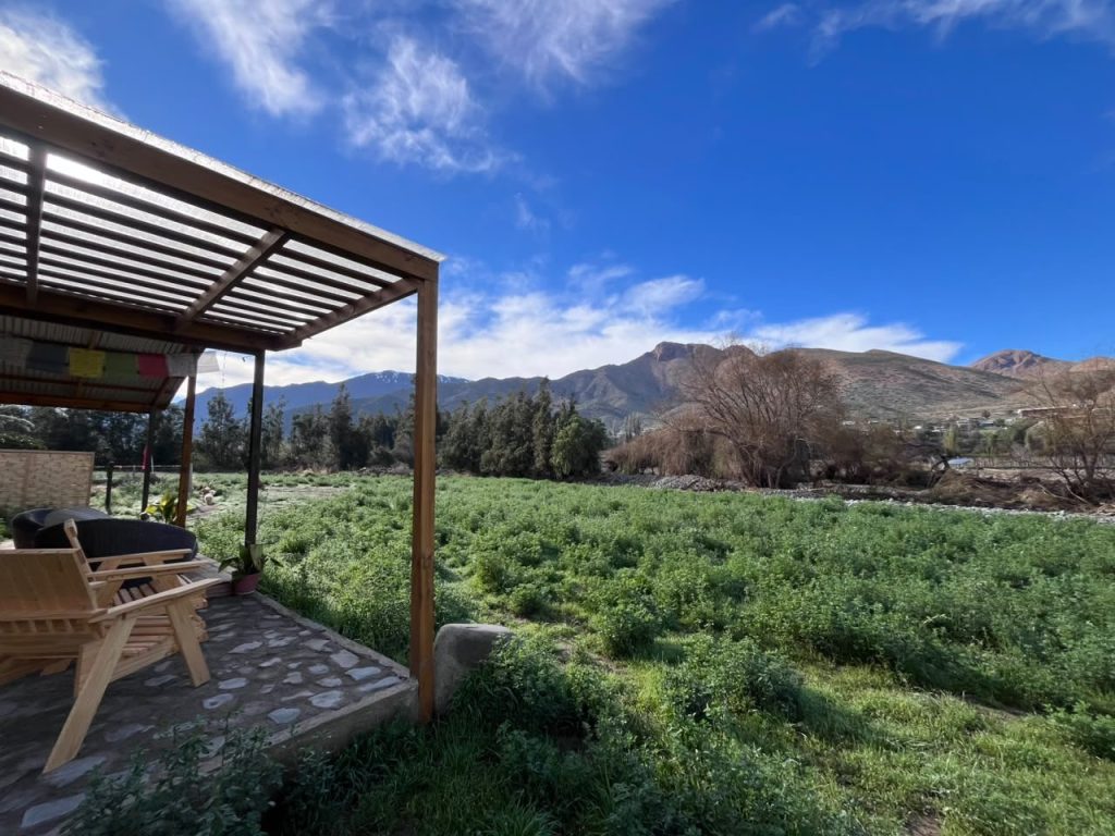 Vista desde la pérgola de la cabaña hacia el campo y las montañas de Río Hurtado